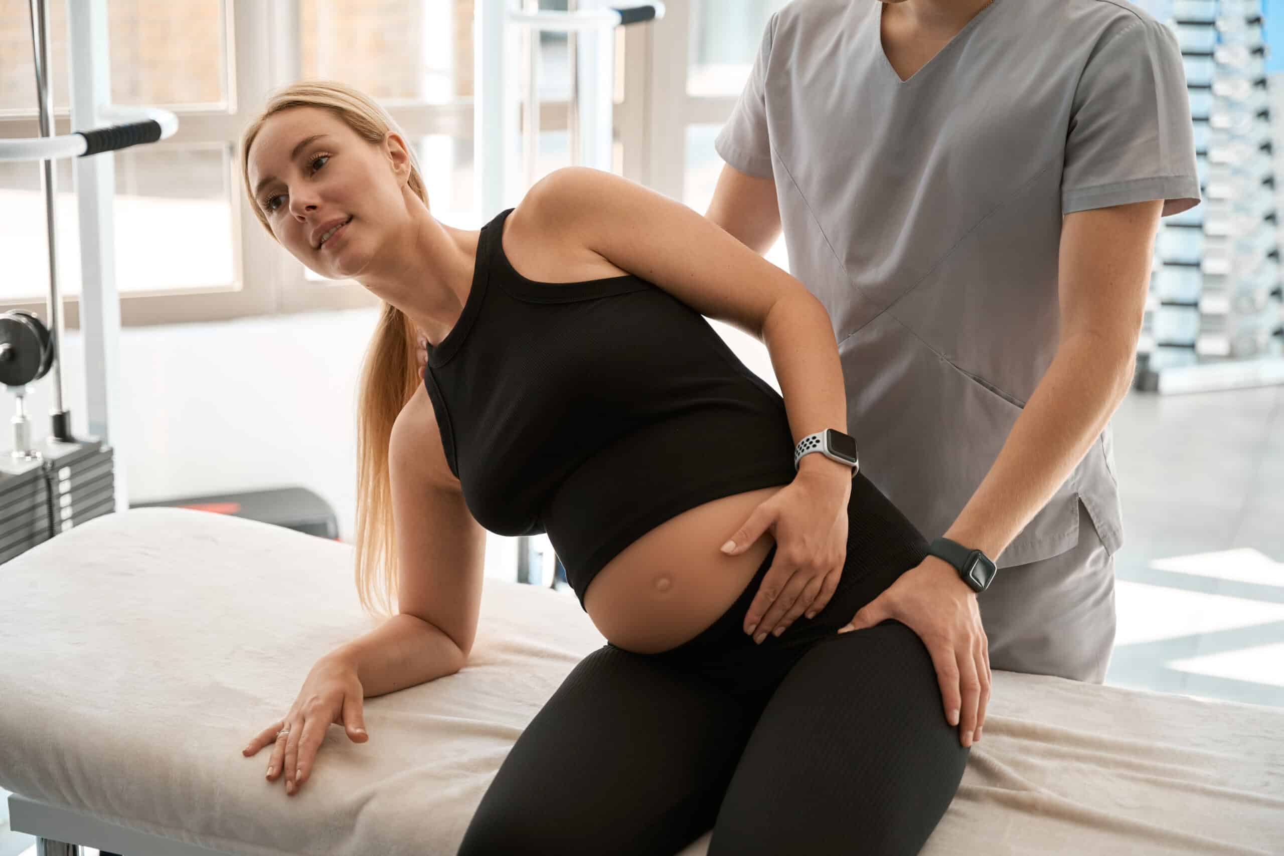 Manual therapy for a pregnant woman in a modern wellness center, indoors with a lot of sunlight