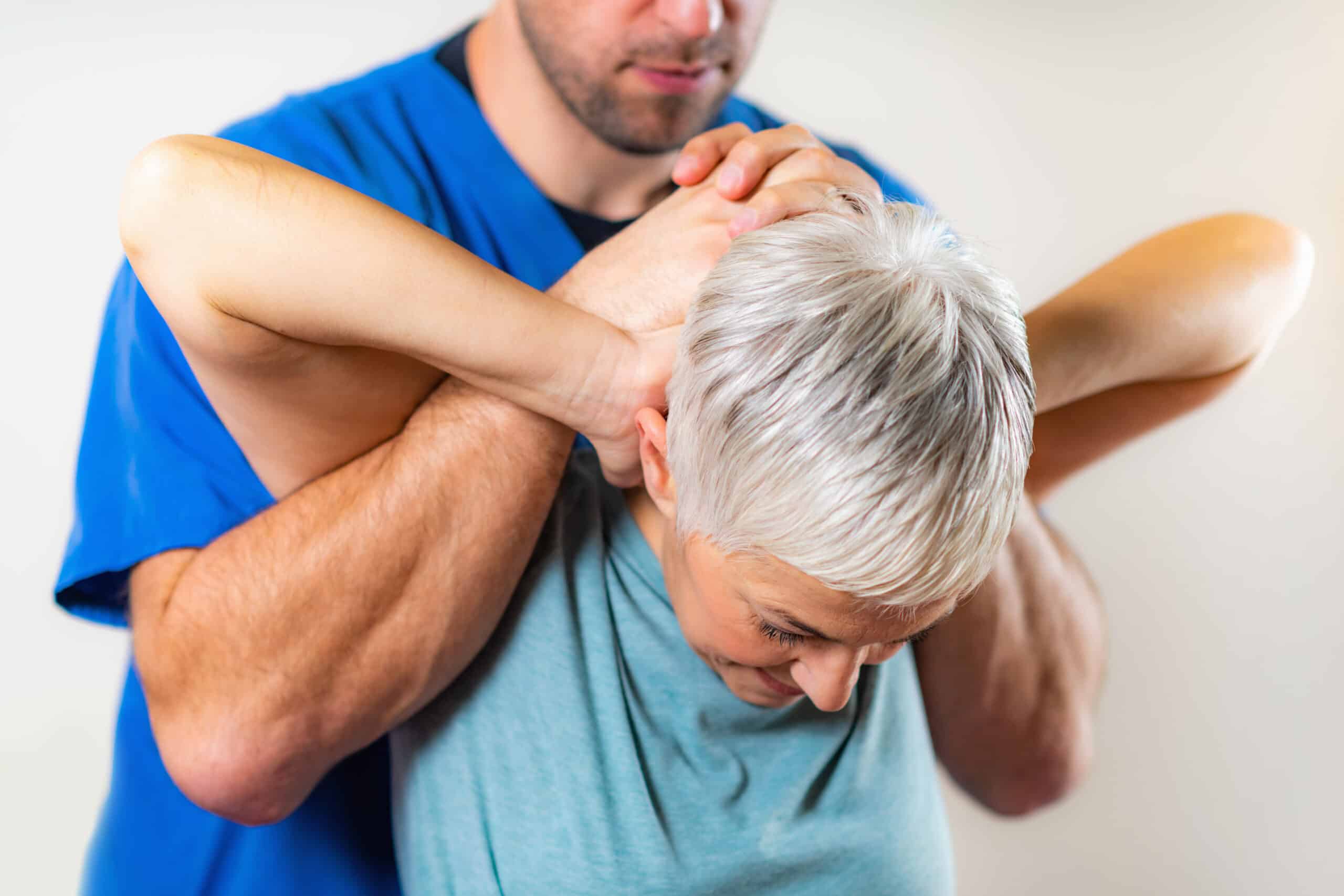 Physical Therapist Stretching Senior Woman’s Neck