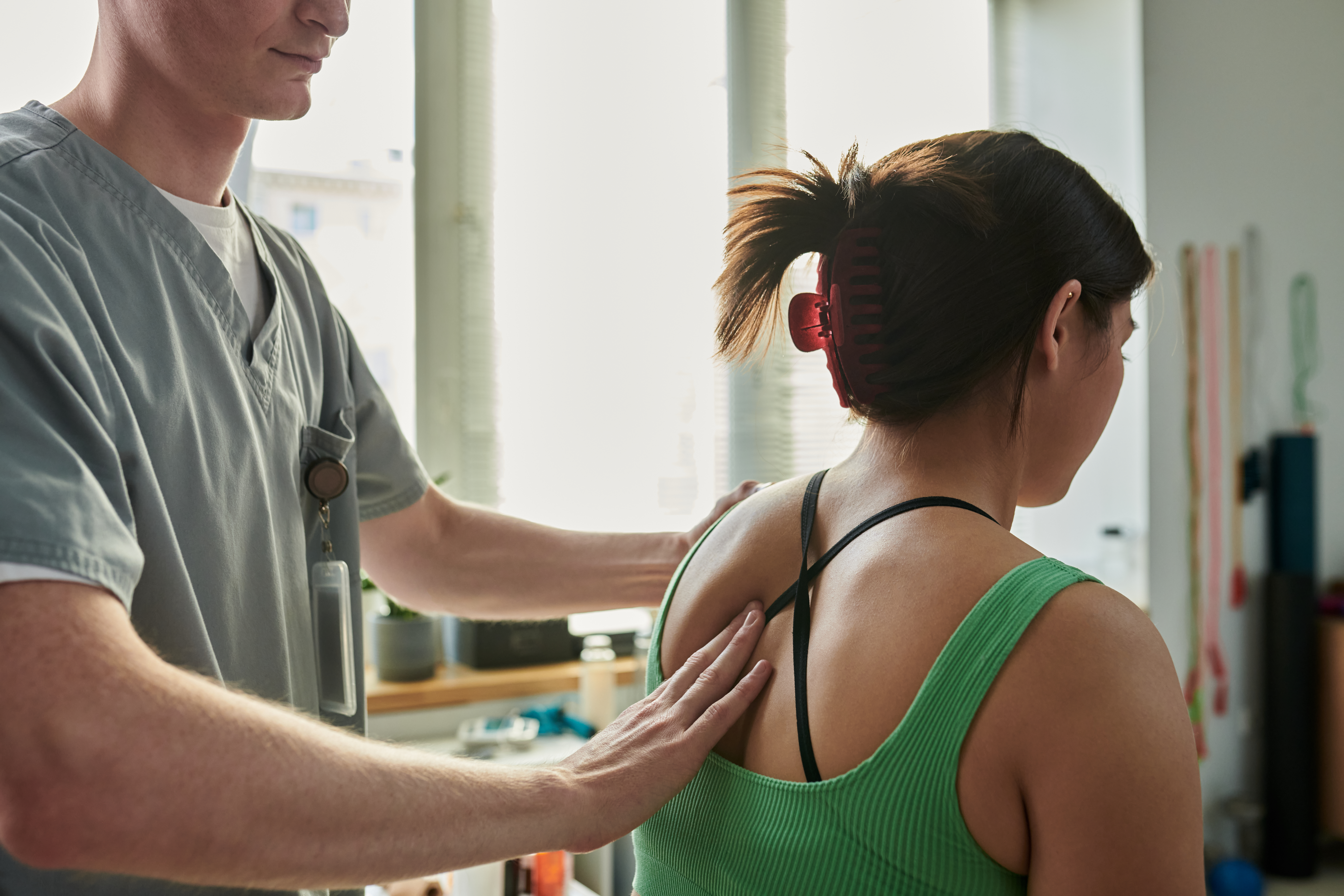 Physiotherapist assisting patient with exercises in clinic, emphasizing rehabilitation and therapy techniques for improving muscle strength and flexibility